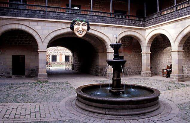 Detalles de la entrada de la Casa de la Moneda en Potosí, Bolivia, mostrando el mascarón tallado en piedra que adorna la entrada, parte de la impresionante arquitectura colonial de este histórico edificio asi como la hermosa pileta de piedra